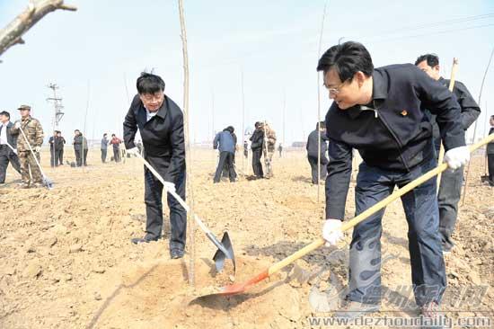 圖為康志民、王春利同黨員志愿者一起參加義務(wù)植樹活動。 記者 永翔 攝